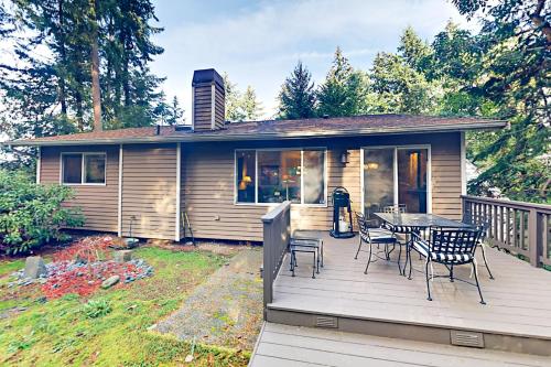 a house with a deck with a table and chairs at Forest Retreat in Shoreline
