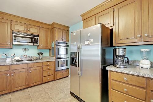 a kitchen with wooden cabinets and a stainless steel refrigerator at 2714 Bayonne Street in Sullivans Island