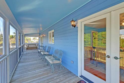 a blue house with chairs on a porch at 2714 Bayonne Street in Sullivans Island