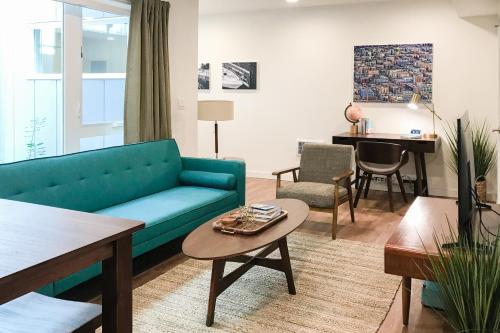 uma sala de estar com um sofá azul e uma mesa em Atrium Unit 105 em Seattle