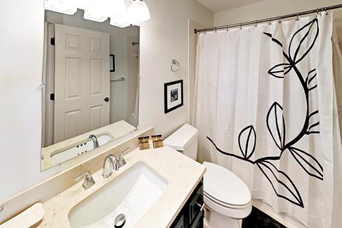 y baño con lavabo, aseo y cortina de ducha. en Pelican Bay 46, en Isle of Palms