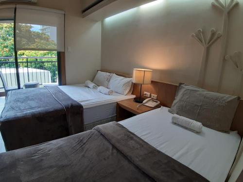 a hotel room with two beds and a window at Cebu City Suites Ramos Tower by P&J in Cebu City