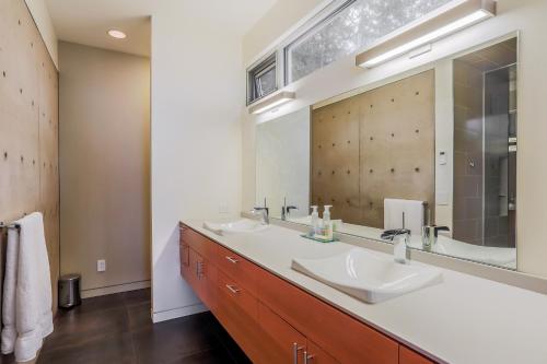 uma casa de banho com 2 lavatórios e um espelho grande em Mountainview Retreat em Fletcher Bay
