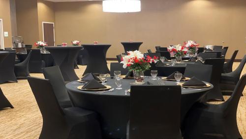 a conference room with tables and chairs with flowers on them at Holiday Inn Owensboro Riverfront by IHG in Owensboro