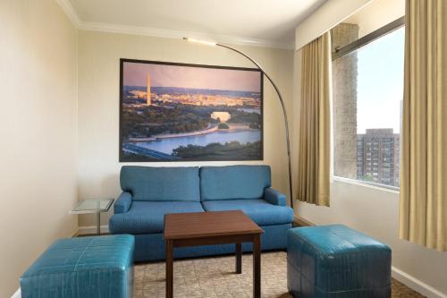 a living room with a blue couch and a large window at Crowne Plaza Crystal City-Washington, D.C. by IHG in Arlington
