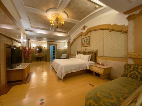 a large bedroom with a bed and a couch at I Travel Motel - II in Kaohsiung