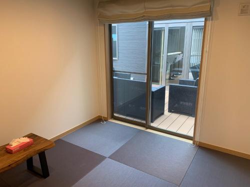 a room with a window and a table and a balcony at KAI Ichinomiya in Ichinomiya