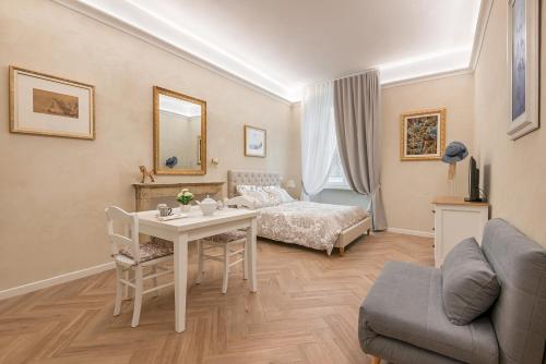 a bedroom with a bed and a table and a couch at Classic Chic - Città Alta in Bergamo