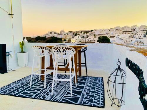 d'une table et de chaises sur un balcon avec vue sur la ville. dans l'établissement Casa Bali. Duplex con terraza privada en centro, à Vejer de la Frontera