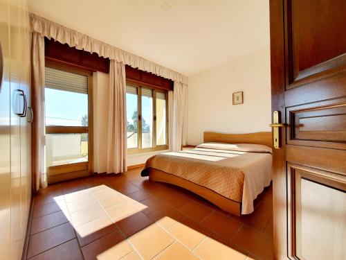 a bedroom with a bed and a large window at Marinaway - Appartamenti a 2 chilometri dal mare in Orosei