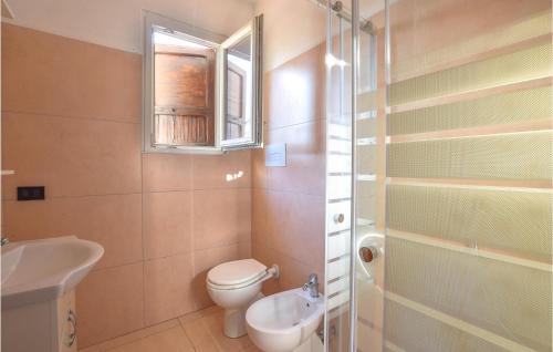 a bathroom with a toilet and a sink and a window at Lovely Home In Manerba Del Garda With Kitchen in Manerba del Garda