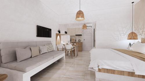 a white bedroom with a bed and a couch at Chouzourakis Studios in Keratokampos