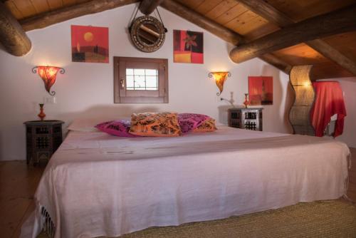 a bedroom with a large white bed in a room at La Casa dell'Artista in Orosei