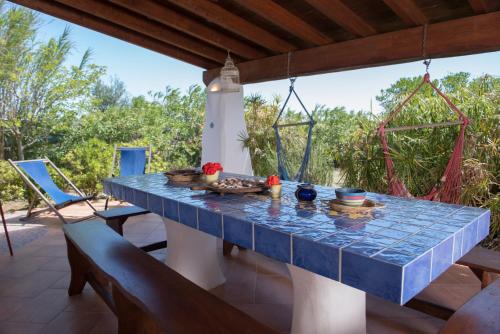 un tavolo con piastrelle blu su un patio con sedie di La Casa dell'Artista a Orosei