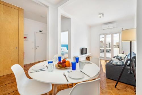 a white dining room with a white table and chairs at RG Sunny Ap in Faro