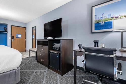 a hotel room with a bed and a flat screen tv at Best Western Bloomington Edina - Minneapolis in Bloomington