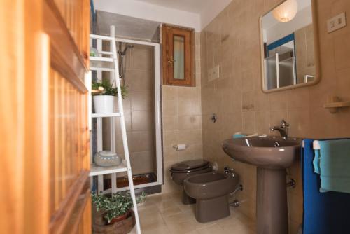 Un baño pequeño con lavabo e inodoro. en Le Sunrise - Appartamenti a 350 mt dal mare e con giardino privato, en Cala Liberotto