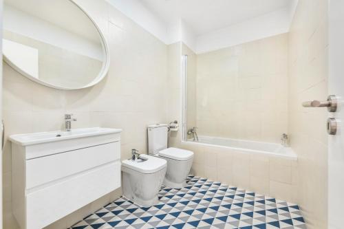 a bathroom with a toilet and a sink and a mirror at RG Sunny Ap in Faro