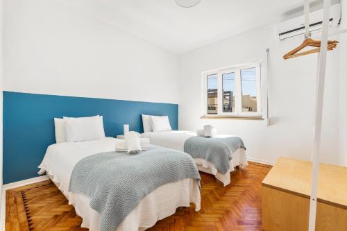two beds in a room with a blue wall at RG Sunny Ap in Faro