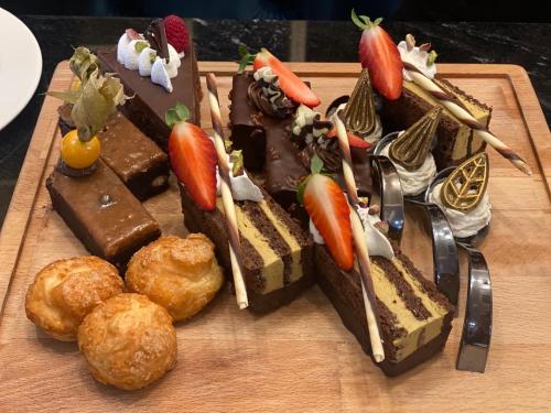 a wooden plate with a chocolate cake with fruit on it at Casa di Fiore SPA and Medical Hotel, Mineral Pools & Private Beach in Kranevo
