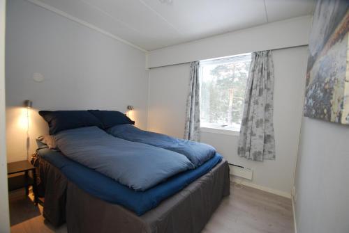 een slaapkamer met een groot blauw bed en een raam bij Fossanåsen Hotel in Flesberg