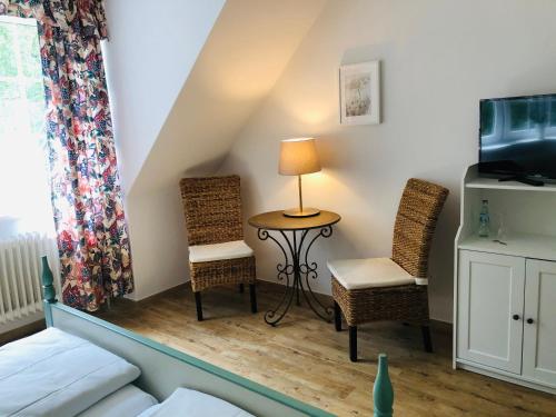 um quarto com uma cama, duas cadeiras e uma mesa em Landhotel Gutshof im Oertzetal in Oldendorf, Südheide em Hermannsburg