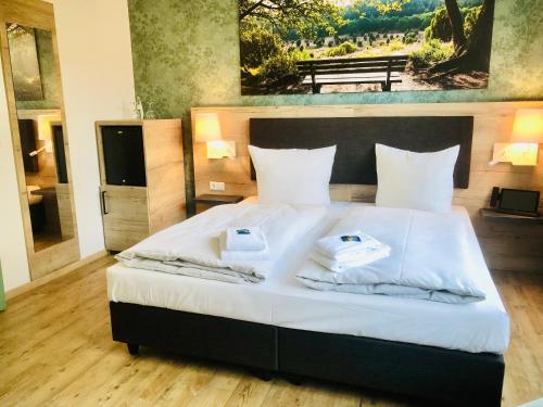 a bedroom with a bed with two towels on it at Landhotel Gutshof im Oertzetal in Oldendorf, Südheide in Hermannsburg