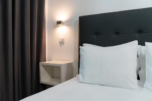 a bed with a black headboard and a white pillow at Hotel A Ponte in Viana do Castelo