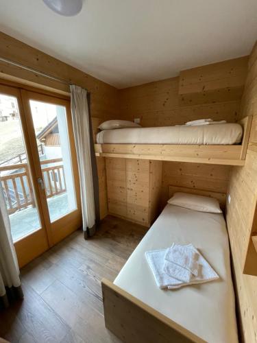 a small room with two bunk beds and a window at Trilocale Ortles - Residenza Vallecetta 2 in Piatta