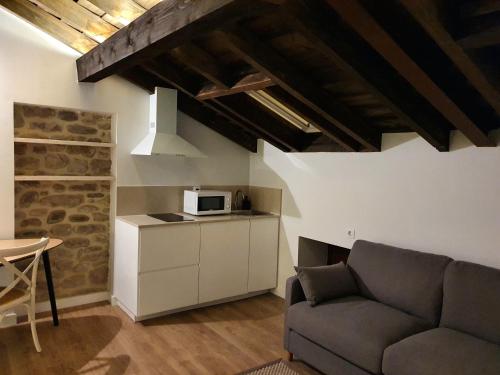 a living room with a couch and a microwave at OTERO DE CAMPOO in Espinilla