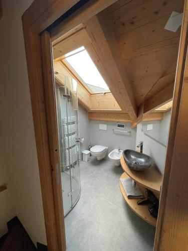 a bathroom with a glass shower and a sink at Mansarda Tresero- Residenza Vallecetta 2 in Piatta