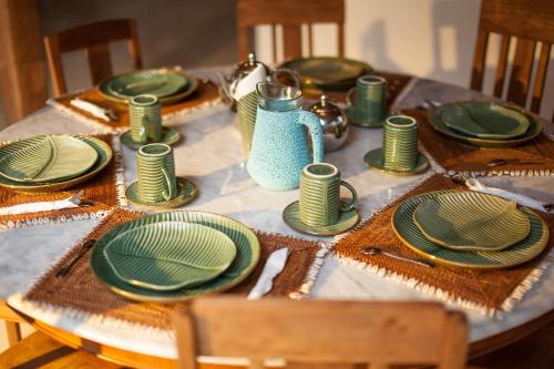 a table with green plates and napkins on it at The Gili Beach Resort in Gili Trawangan