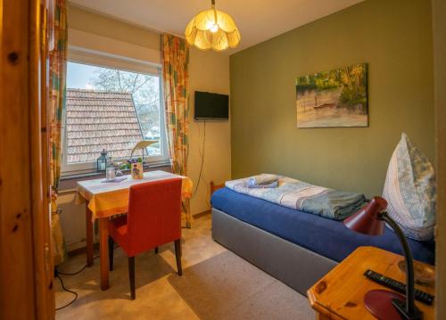 a bedroom with a bed and a table and a window at Linde Oberachern in Achern