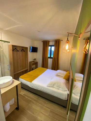 a bedroom with a bed and a bathroom with a sink at Hotel U Catagnu in San-Nicolao