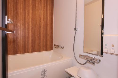 a bathroom with a tub and a toilet and a sink at Sapporo Washington Hotel Plaza in Sapporo