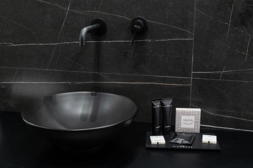 a bathroom sink with a faucet on a wall at Marmur Suite in Palermo