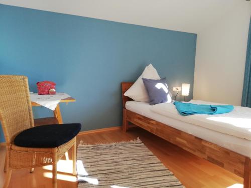 1 dormitorio con 1 cama con pared azul en Ferienwohnung Alpenlodge, en Rieden