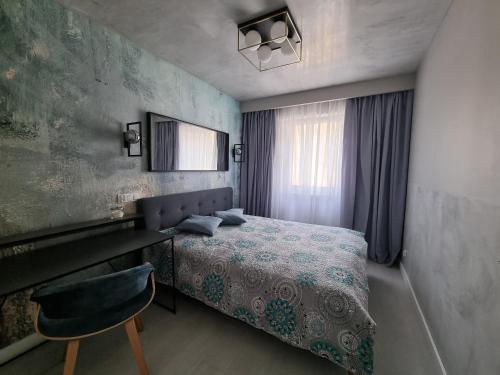 格但斯克的住宿－M&K Apartamenty - Bałtyk，一间卧室配有一张床、一张桌子和一把椅子