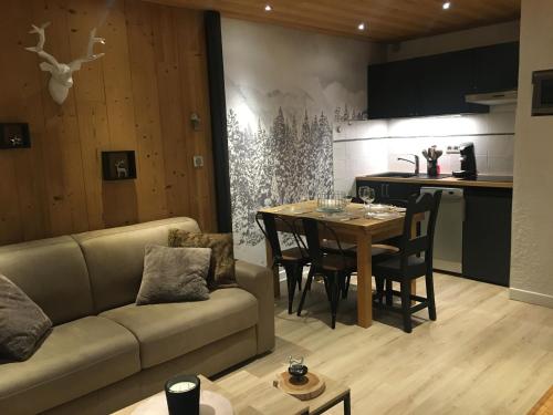 a living room with a couch and a table at Les Deux Alpes, Le Lauvitel, appartement cosy, pied des pistes, 2 adultes 2 enfants in Les Deux Alpes