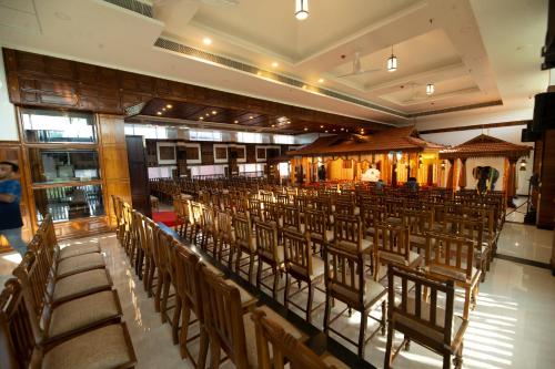 a room with rows of chairs in a building at Hotel Guruvayur Darshan in Guruvāyūr