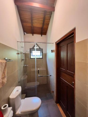 a bathroom with a toilet and a shower with a glass door at Morning Star in Mirissa