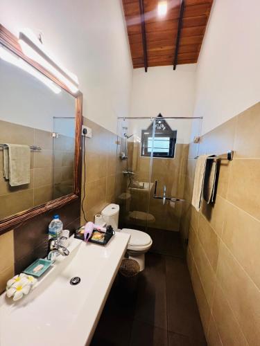 a bathroom with a sink and a toilet and a mirror at Morning Star in Mirissa