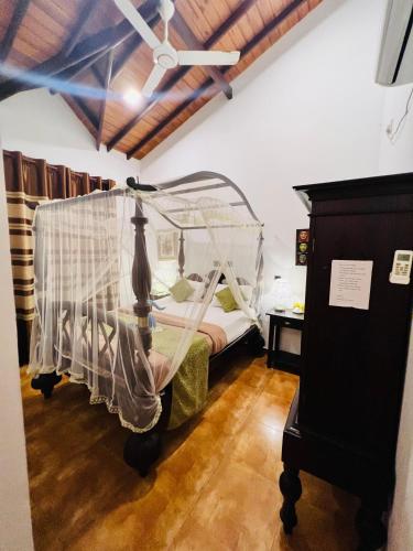 a bedroom with a bed with a mosquito net at Morning Star in Mirissa