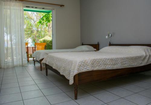 two beds in a room with a window at ΑΚΤΗ ΞΟΒΡΙΟΣ in Kivérion
