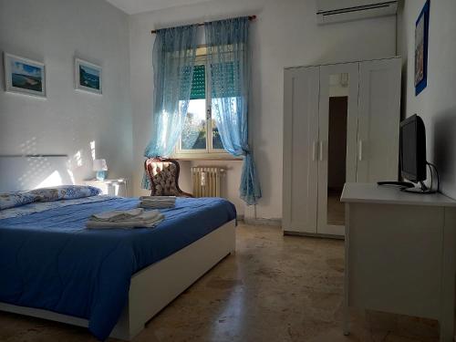 a bedroom with a bed and a television and a window at A Casa di Lidia B&B Gaeta in Gaeta