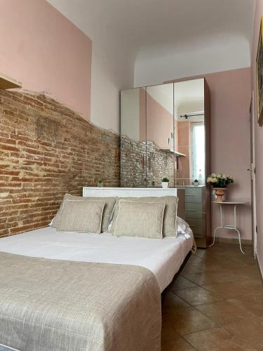 a bedroom with a large bed and a brick wall at Homelink Firenze - The Key in Florence