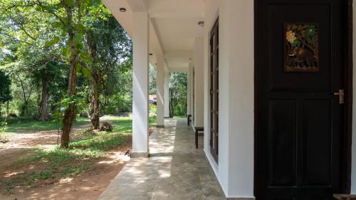 a black door on the side of a house at Iwamisou in Sigiriya