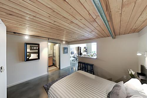 sypialnia z łóżkiem i drewnianym sufitem w obiekcie 19th Avenue Lofts Unit 213 w mieście Seattle