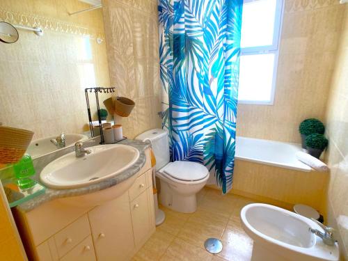 ein Badezimmer mit Waschbecken, WC und Duschvorhang in der Unterkunft Spanish Connection - Puerto Mar in La Manga del Mar Menor