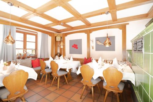a restaurant with white tables and chairs in a room at Ferien-Apartment im Genusshotel Hirschen (Südschwarzwald) in Kleines Wiesental